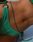 Side view of model in green bikini wearing Malachite Quartz Juliana Belly Chain at hip