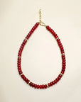 Lilou necklace in cherry quartz displayed flat, featuring deep red beads accented with gold dividers and a delicate chain clasp for a bold and elegant design.