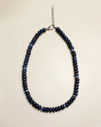 Lilou necklace in sapphire quartz displayed flat, featuring deep blue beads with silver accents and a delicate chain clasp, offering a refined and elegant style.