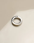 Detailed image of 'The Ring' accessory in silver, highlighting its smooth finish and functional clasp, perfect for integrating with phone wristlets and charms.