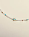 Close-up of the Julianna Necklace in Moonstone, highlighting the turquoise enamel evil eye charm and delicate gold accents.