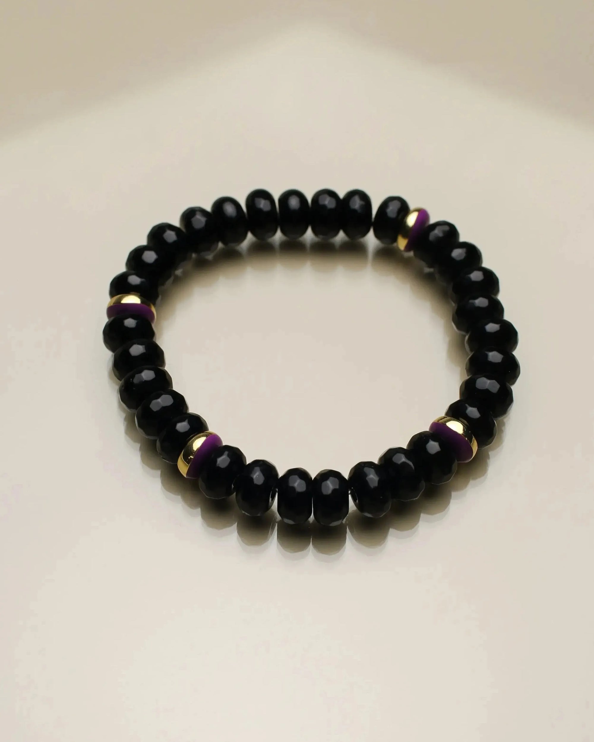 Minimalist Aya bracelet with onyx quartz beads, accented by gold dividers and subtle purple details for a sleek, modern look.