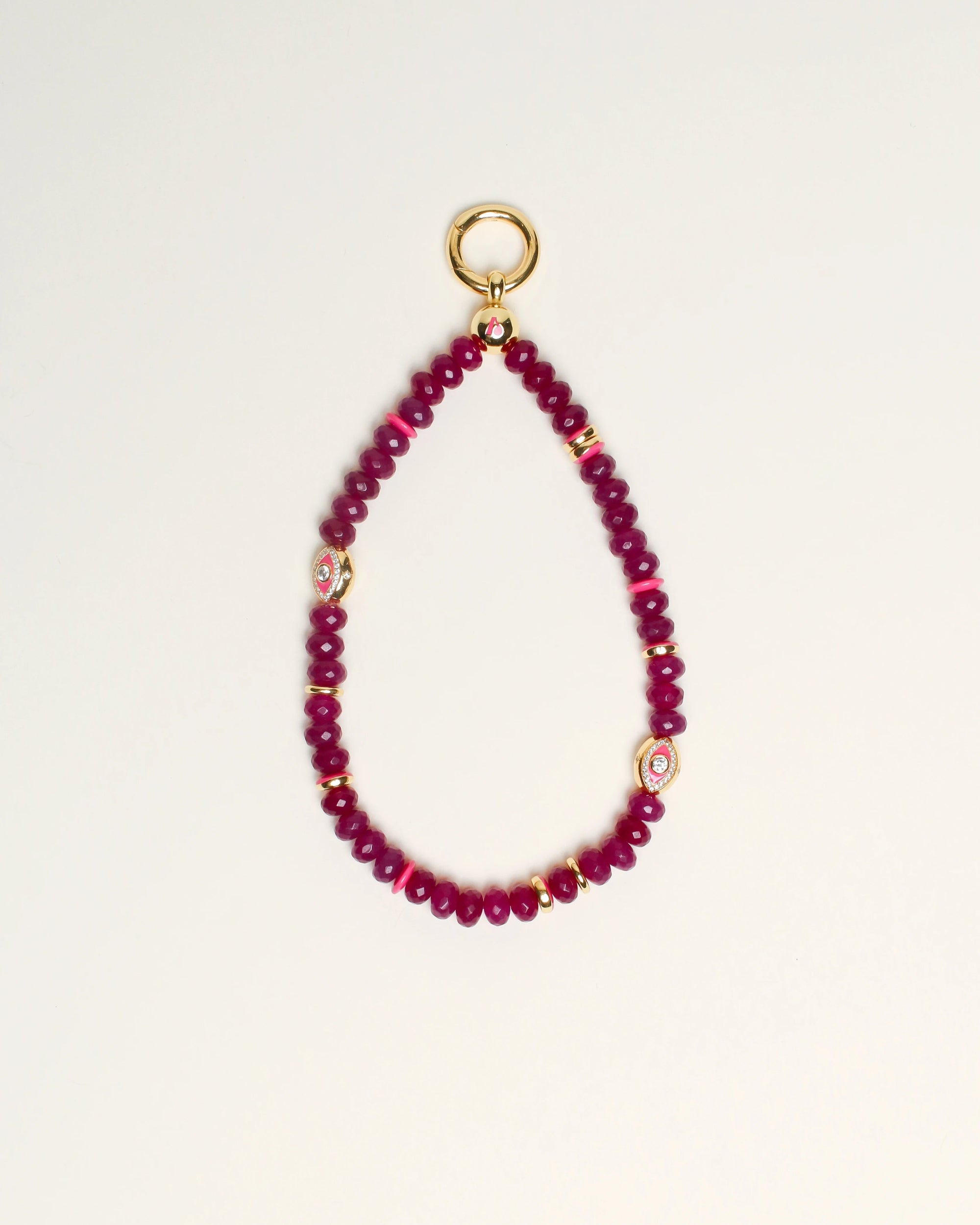 Close-up of Leah Bag Charm in Amethyst – A faceted amethyst quartz bag charm adorned with 14k gold-plated details and Evil Eye charms, designed for cleansing and well-being.