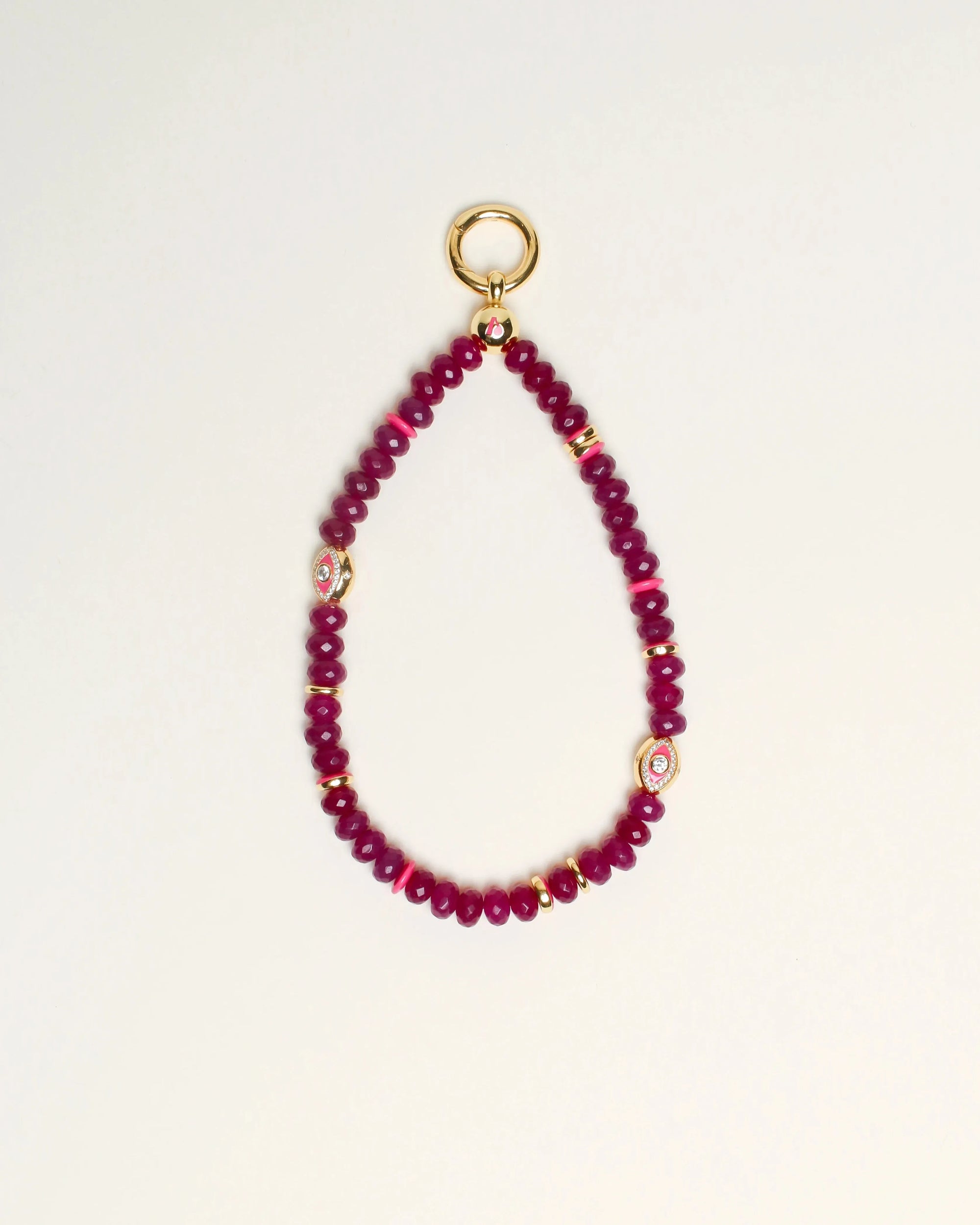 Close-up of Leah Bag Charm in Amethyst – A faceted amethyst quartz bag charm adorned with 14k gold-plated details and Evil Eye charms, designed for cleansing and well-being.