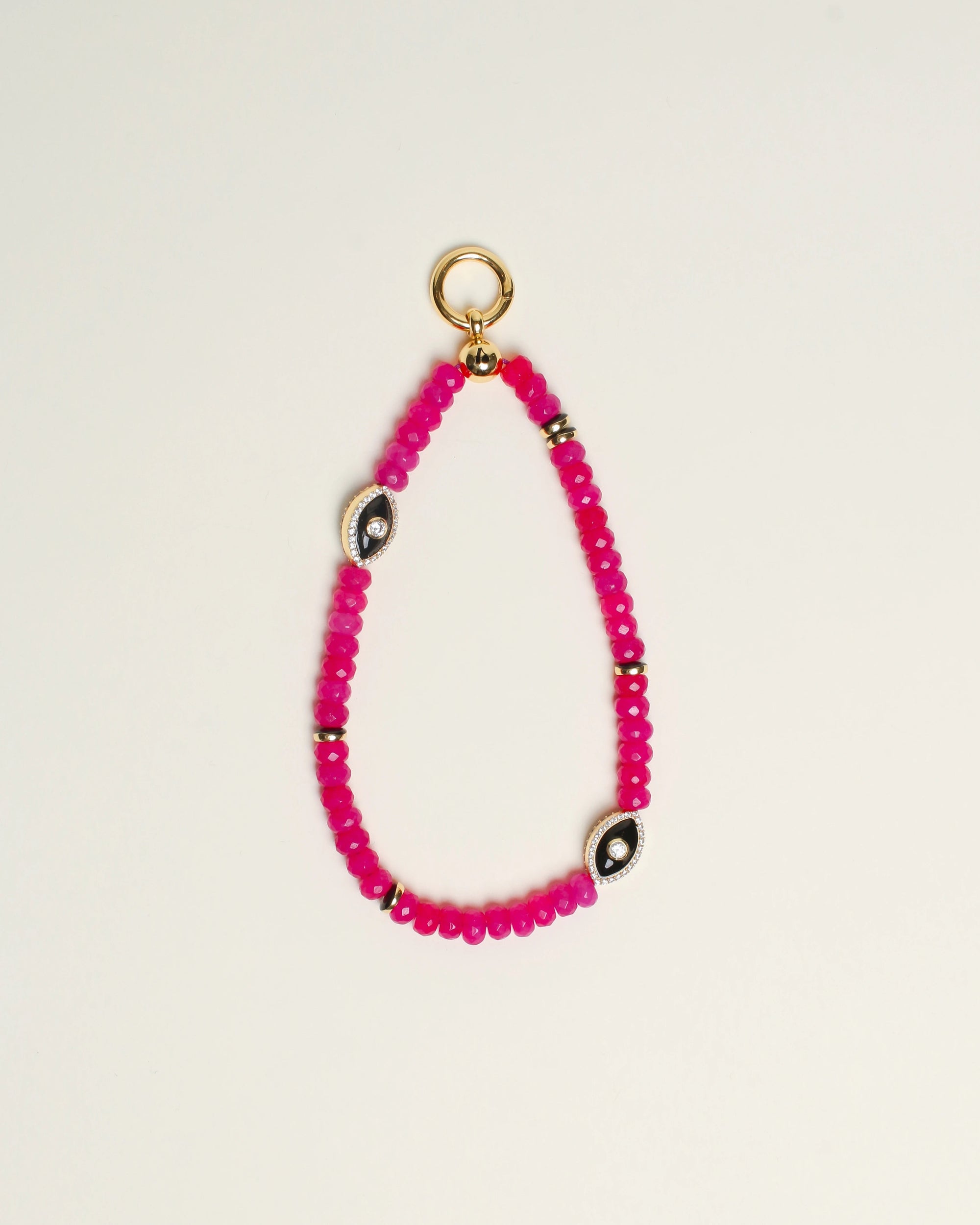 Close-up of Stella Bag Charm in Pink – A luxurious bag charm featuring vibrant pink quartz beads, 14k gold-plated charms, and a zirconia diamond Evil Eye charm for a bold, elegant look.