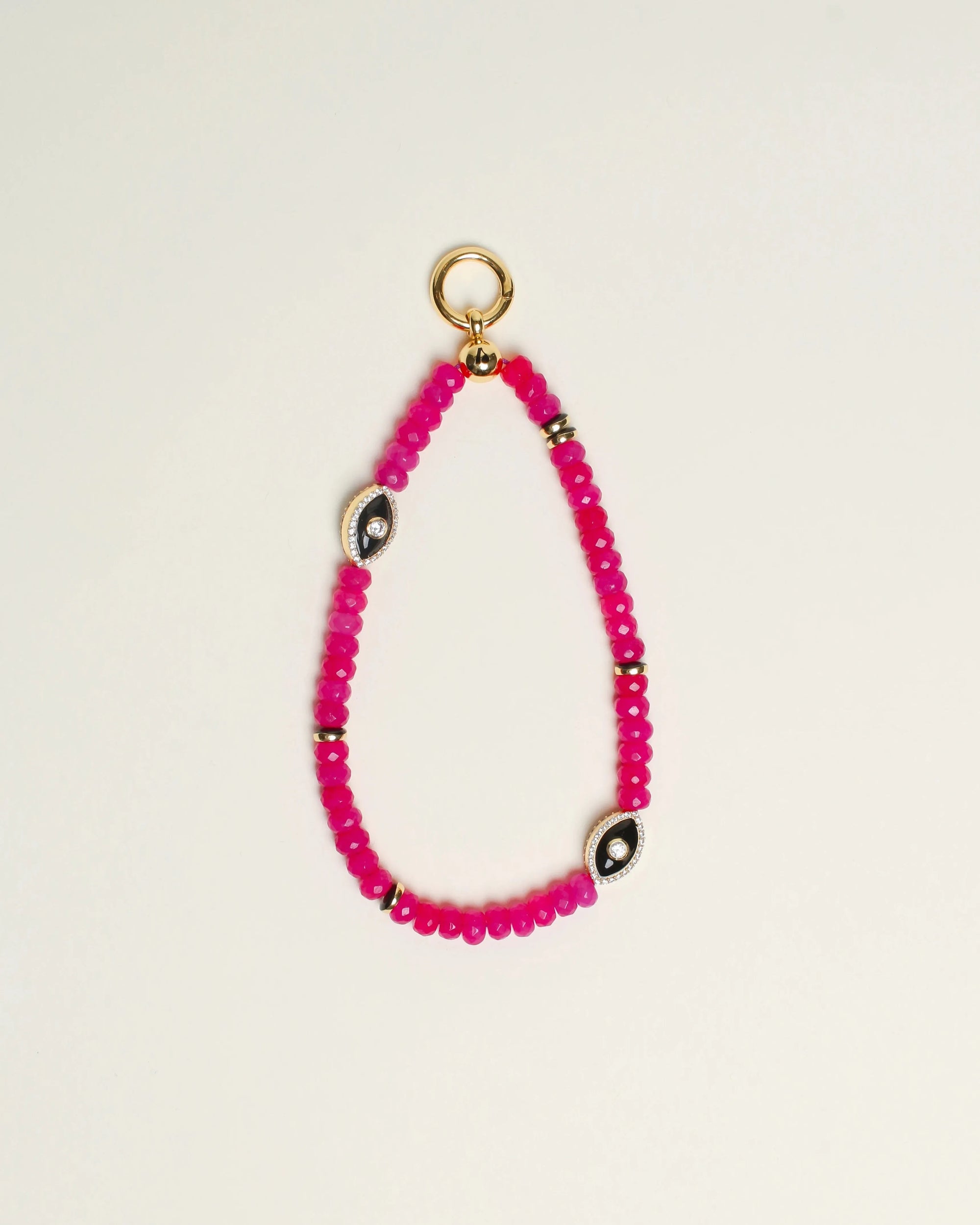 Close-up of Stella Bag Charm in Pink – A luxurious bag charm featuring vibrant pink quartz beads, 14k gold-plated charms, and a zirconia diamond Evil Eye charm for a bold, elegant look.