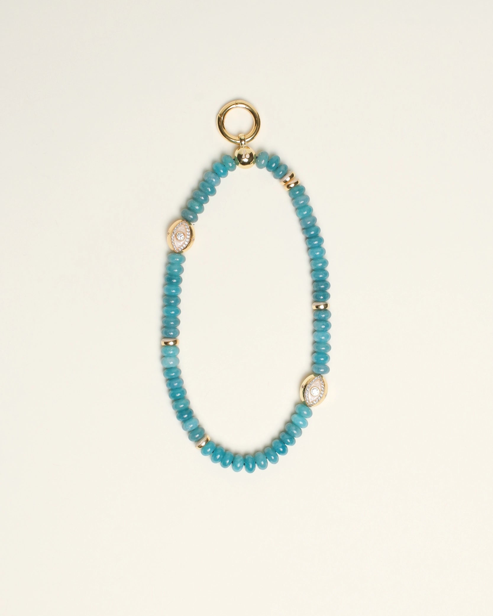 The Leah Bag Charm in Apatite, displayed against a neutral background, showcasing its semi-precious apatite quartz beads, 14k gold-plated accents, and Evil Eye charms for an elegant and protective design.