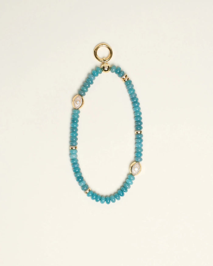 The Leah Bag Charm in Apatite, displayed against a neutral background, showcasing its semi-precious apatite quartz beads, 14k gold-plated accents, and Evil Eye charms for an elegant and protective design.