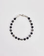 The David Bracelet in Silver laid flat, showcasing its polished silver finish, black onyx beads, and a single evil eye charm with a black CZ diamond.