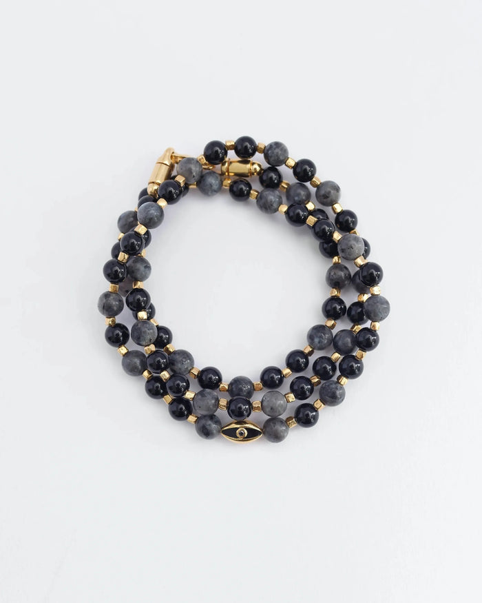 The David Wrap in 18K Gold laid flat and wrapped, showcasing its convertible design with dual gold-plated evil eye charms, black onyx and black labradorite quartz beads, and a polished gold finish.