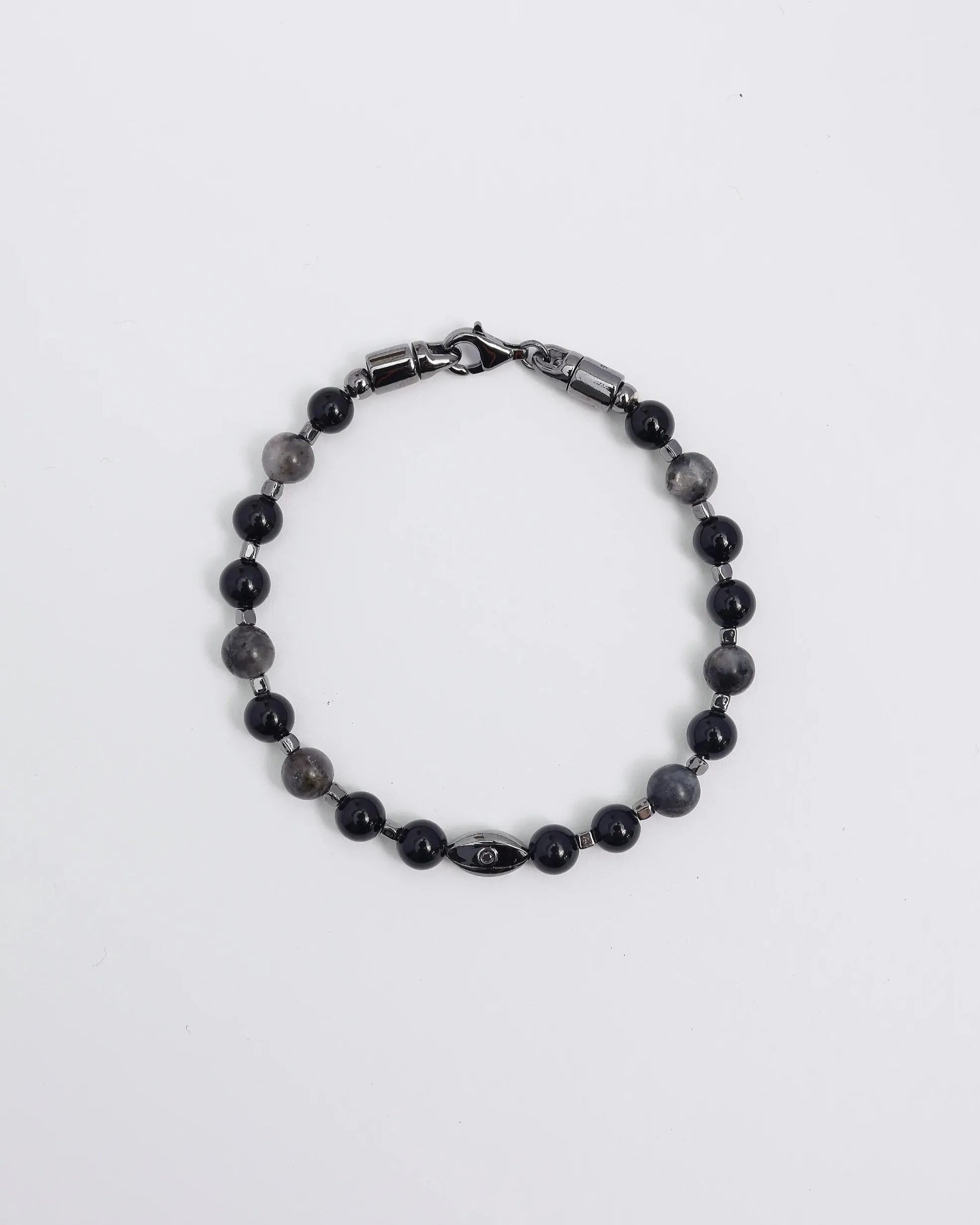 A close-up shot of a man resting his hand on his head while wearing the David Bracelet in Black Rhodium, emphasizing its sleek, understated edge and dark stone accents.