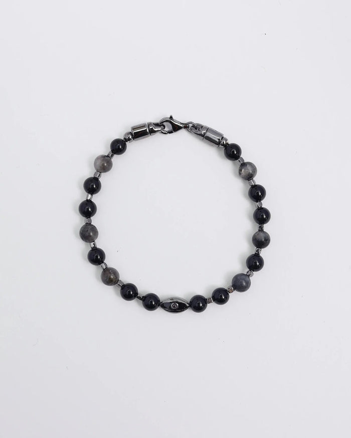 A close-up shot of a man resting his hand on his head while wearing the David Bracelet in Black Rhodium, emphasizing its sleek, understated edge and dark stone accents.