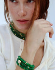 Model wearing the Leah Emerald Bracelet set, paired with a matching Lilou Emerald necklace. The bracelet stack showcases green quartz beads with gold accents, exuding a luxurious yet effortless look.