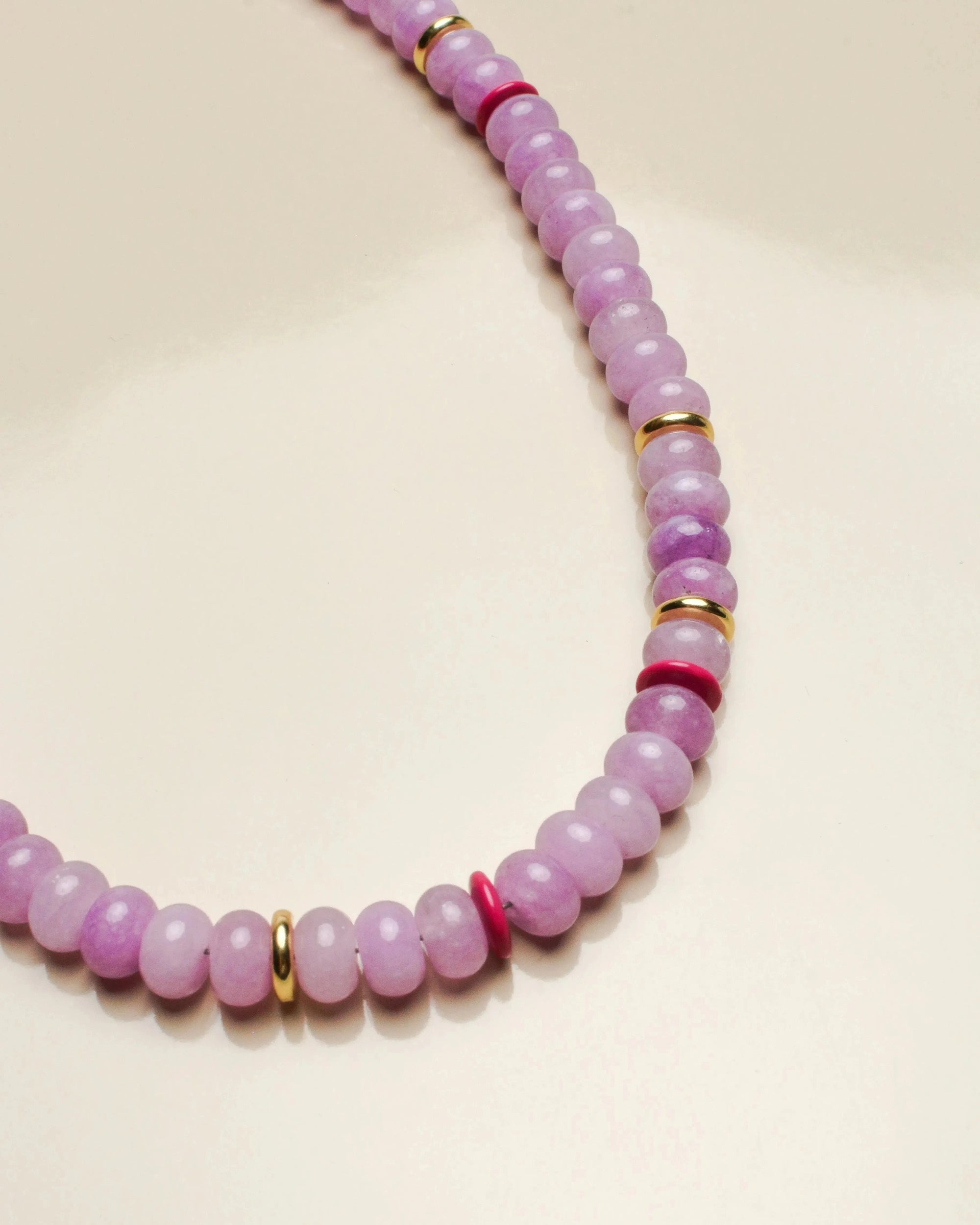 Close-up of the Ethan lavender necklace, showcasing the smooth lavender beads accented with pink and gold dividers for a refined look.