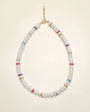 Ethan necklace in white quartz displayed in a flat-lay view, featuring milky white beads accented with multicolored dividers and gold detailing, finished with a delicate chain clasp.