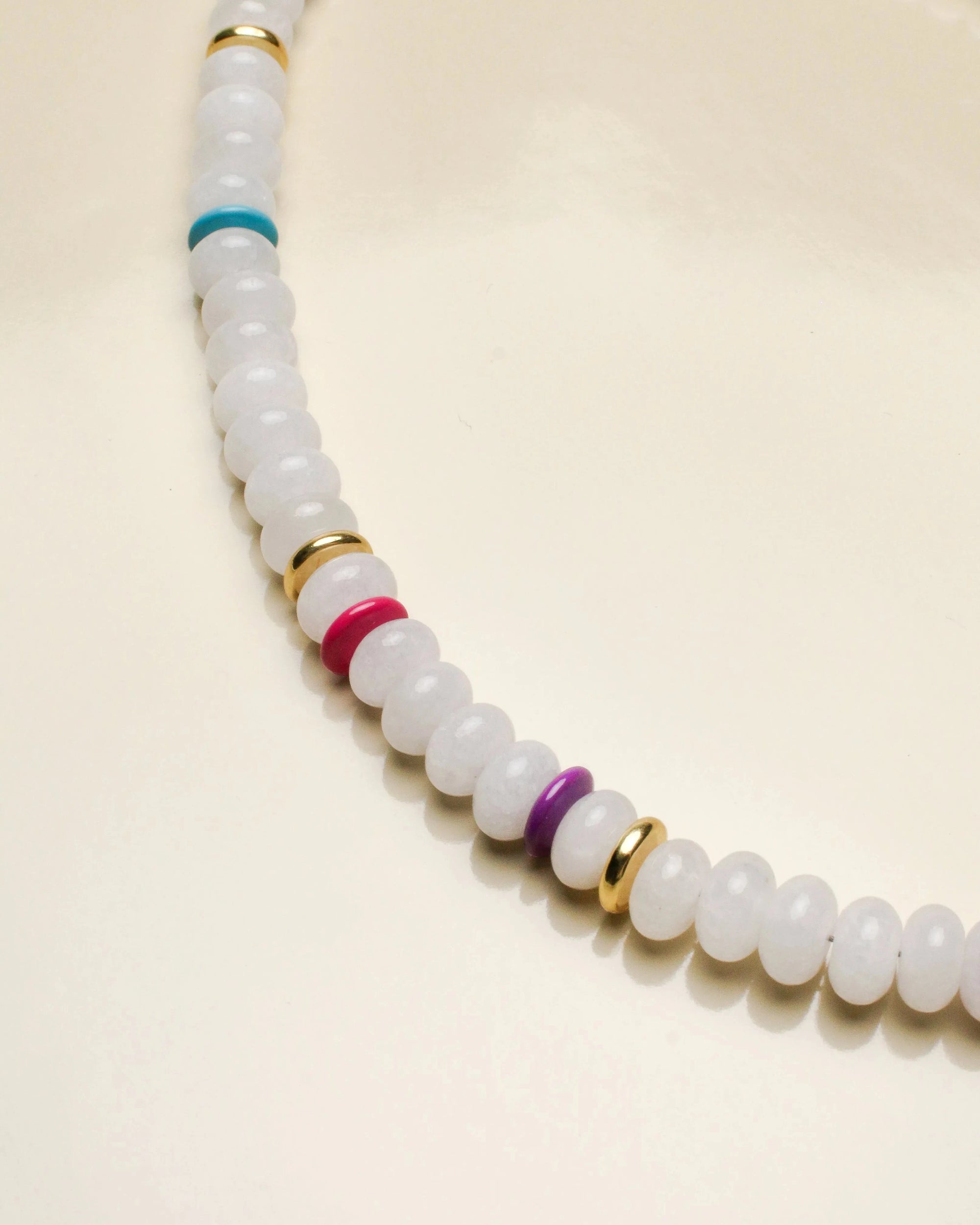 Detailed view of the Ethan white quartz necklace, showcasing the striking mix of milky white beads with vibrant multicolored and gold accents for an elegant touch.