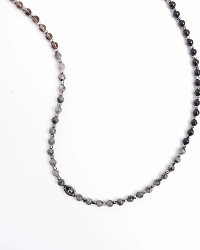 The Ethan Wrap in Silver laid flat in a curved shape, emphasizing the length, dual evil eye charms, and polished silver finish.