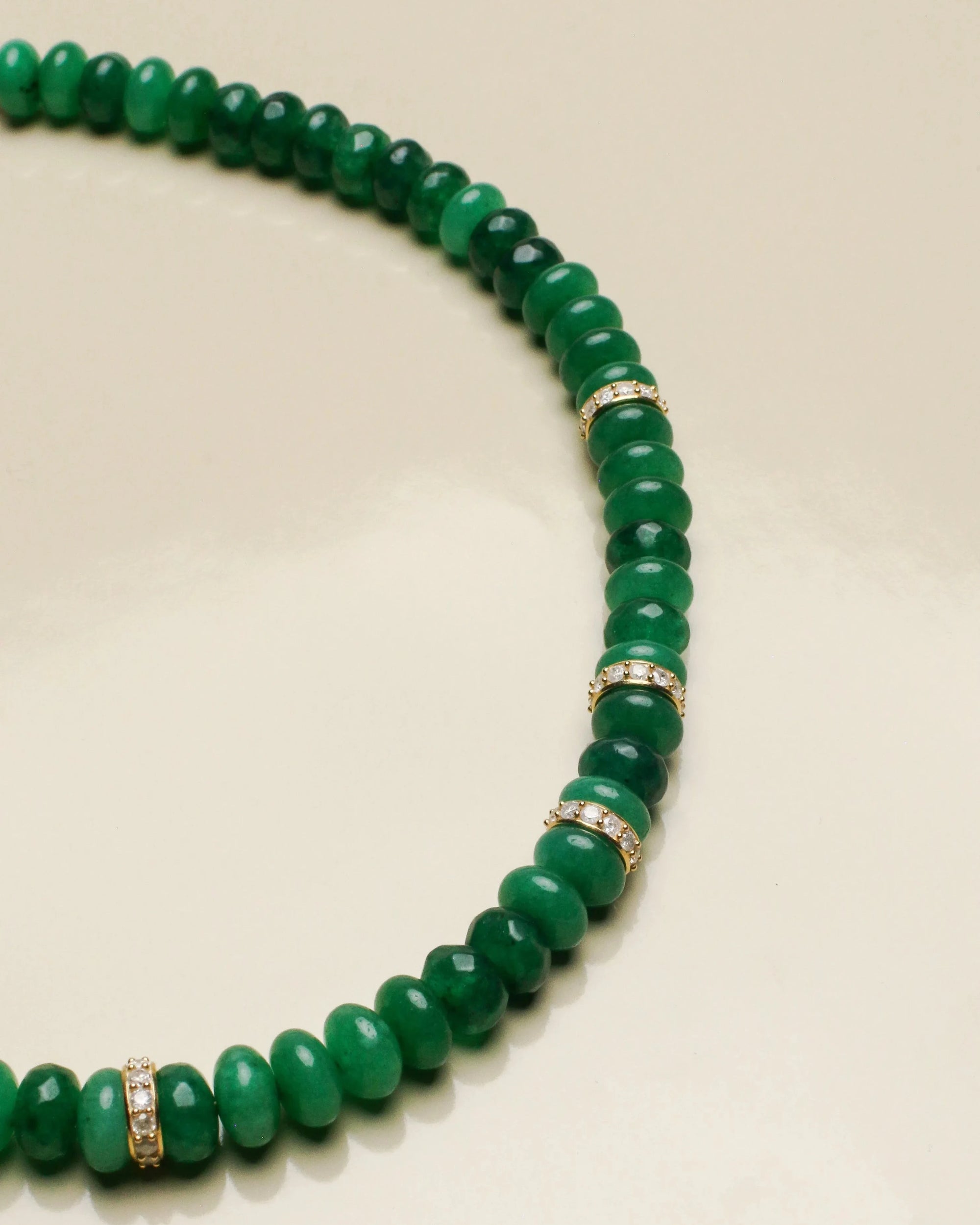 Close-up of the Fanny emerald quartz necklace, highlighting the rich green beads contrasted with sparkling solid gold and diamond accents for an opulent touch.