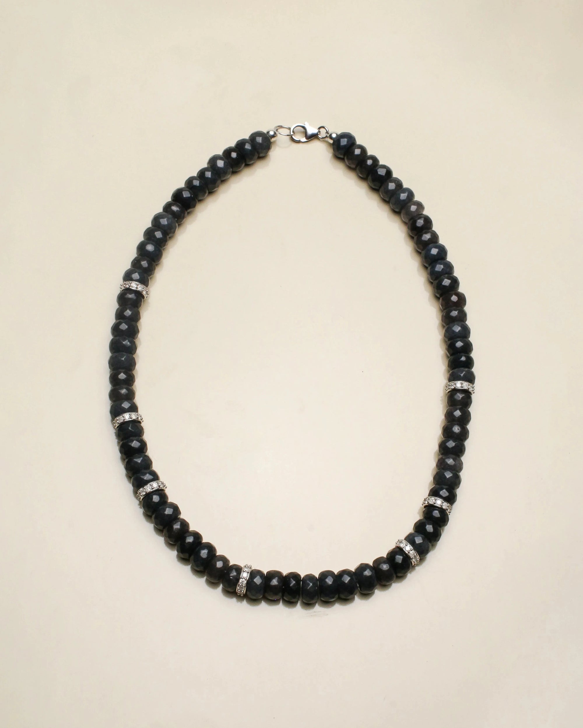 Fanny necklace in onyx black displayed flat, featuring deep black beads contrasted with sections of white solid gold and diamond accents, creating a luxurious and bold design.