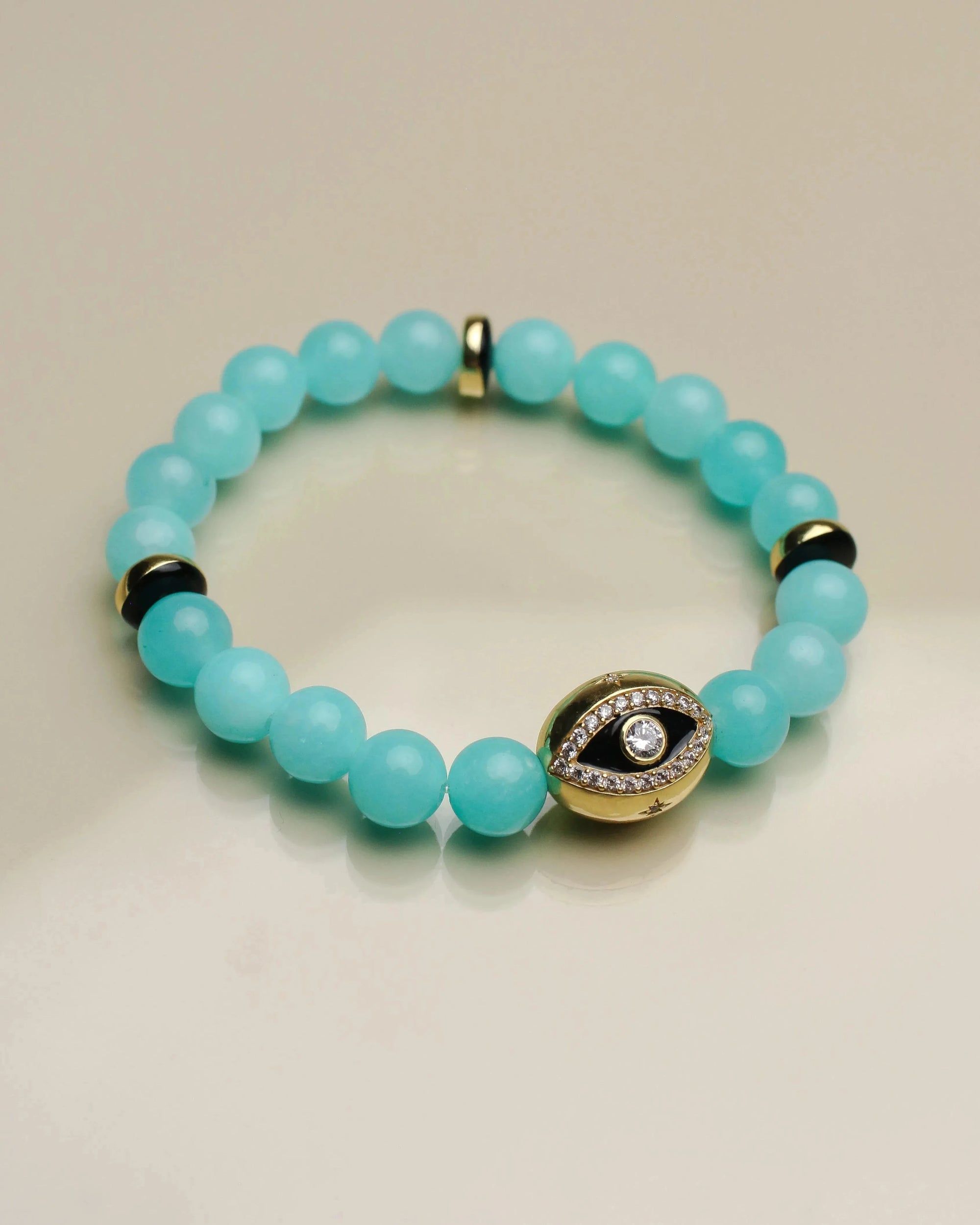 Close-up view of a single Leah aqua bracelet from the set, highlighting its soft blue beads, gold accents, and a gold evil eye charm for a stylish touch.