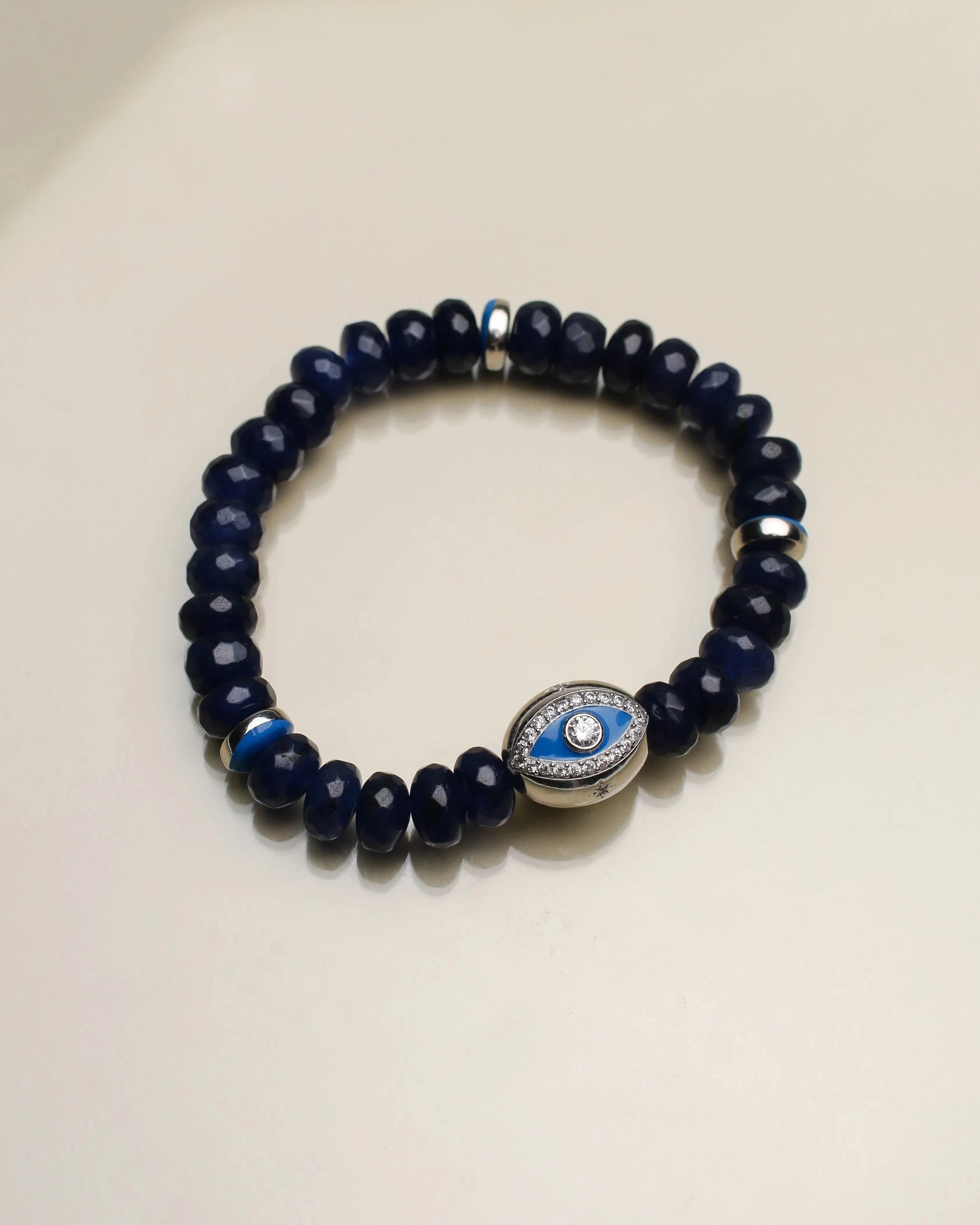 Close-up of a single Leah sapphire quartz bracelet, featuring dark blue beads with a central evil eye charm surrounded by silver dividers for a bold, protective statement.