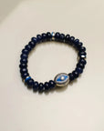 Close-up of a single Leah sapphire quartz bracelet, featuring dark blue beads with a central evil eye charm surrounded by silver dividers for a bold, protective statement.