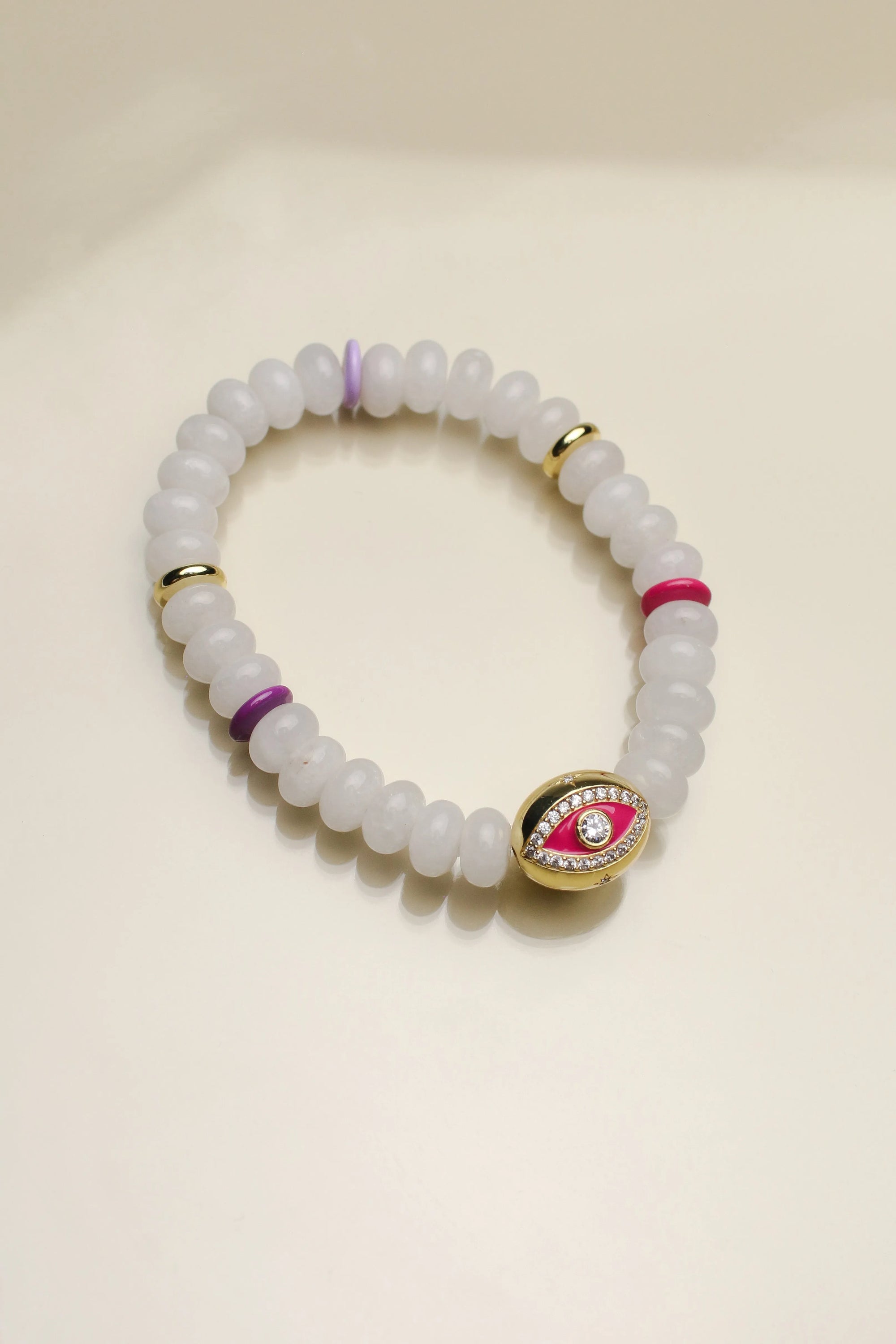 A single Leah white bracelet arranged flat, highlighting the milky white beads, colorful dividers, and the central eye charm for a bright and balanced design.