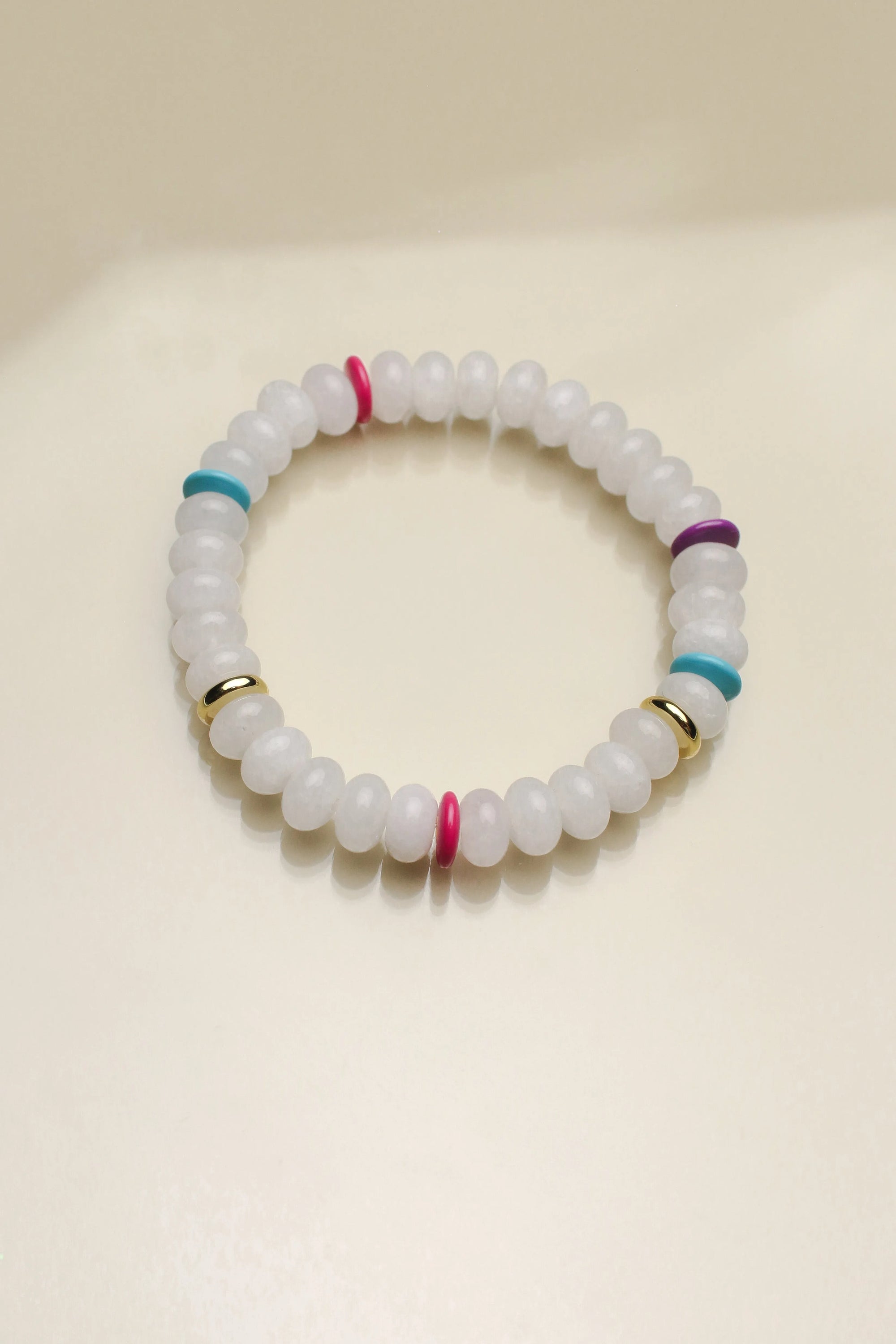 Close-up of a single Leah white bracelet from the set, emphasizing the soft white beads with colorful dividers and a striking central eye charm.