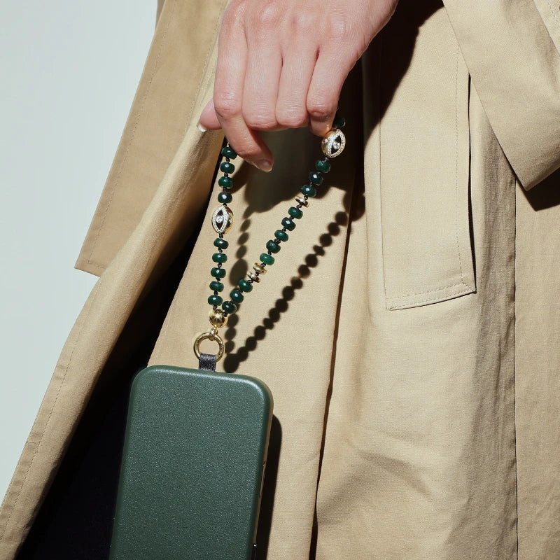 Leah phone charm in emerald quartz featuring green gemstone beads and gold plated hardware worn as a luxury phone accessory.