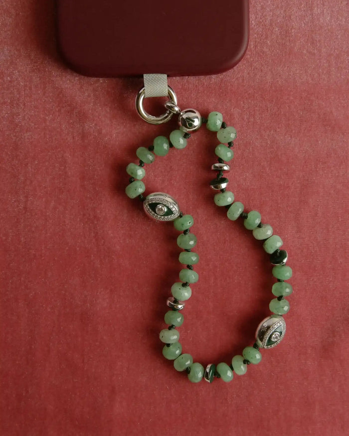 Natural jade Leah Phone Charm displayed in a heart-shaped form on a deep red background.