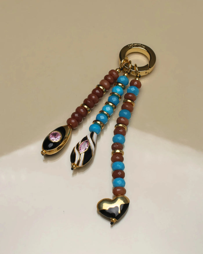 Close-up of the Liora Bag Charm in Azure & Espresso, featuring semi-precious azure and espresso beads with gold accents and heart and teardrop charms.