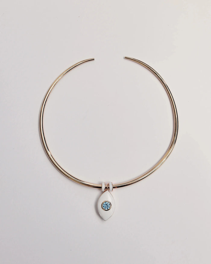 Gold collar necklace featuring a single blue ceramic evil eye charm with white enamel dividers, displayed against a neutral background.