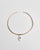 Gold collar necklace featuring a ceramic evil eye charm with a soft pink CZ crystal and two white enamel dividers, shown flat against a white background