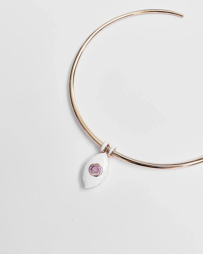 Overhead shot of the necklace laid flat, displaying the gold structure and delicate pink charm.