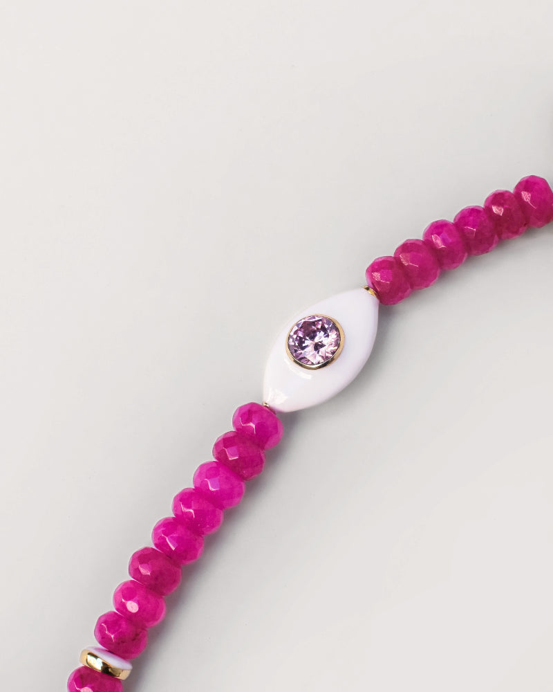 Close-up view of the Mano phone wristlet in hot pink quartz, featuring vibrant pink beads accented with a central white charm set with a pink gemstone, creating a bold and eye-catching detail.