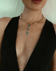 Model wearing the necklace with a deep V black dress, showing how it elegantly accentuates the neckline.