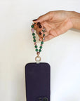 Hand holding the Mini Leah Emerald Quartz Phone Charm, showcasing green quartz beads and gold accents.