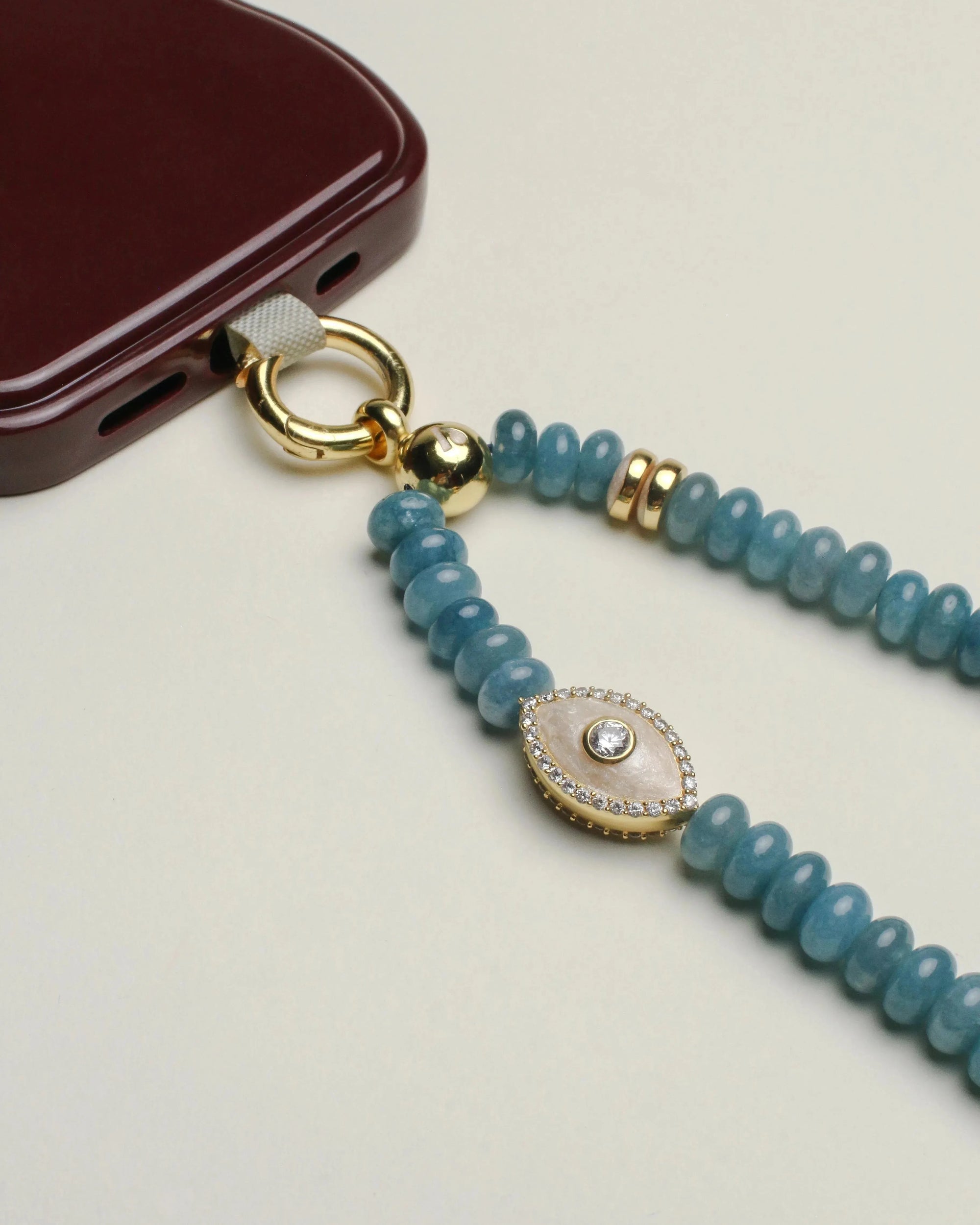 Close-up view of the Stella wristlet showcasing apatite beads and white evil eye-shaped charms, providing a blend of elegance and protective symbolism.