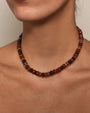 The Valerie Necklace in Espresso styled on a model's collarbone, emphasizing its earthy tones and timeless elegance