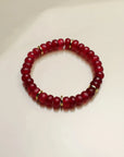 Close-up of a single Zoe cherry quartz bracelet, capturing the vivid red tones and intricate gold detailing.