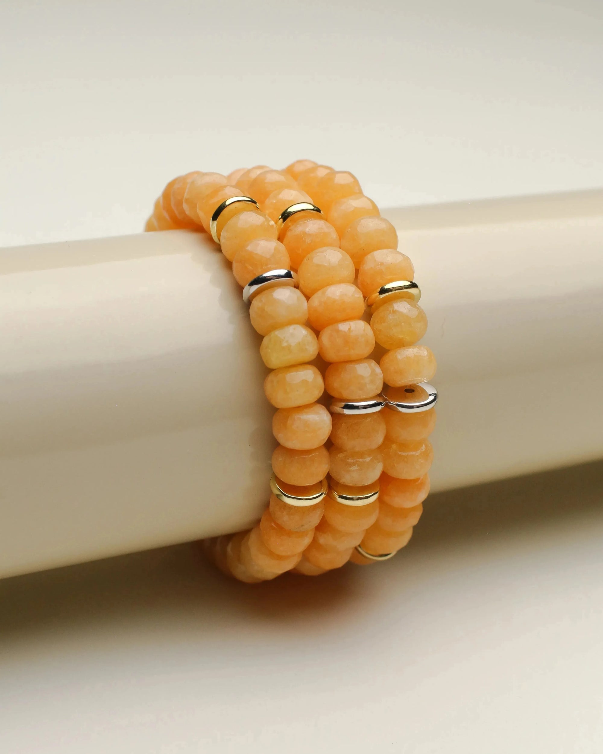 Close-up view of three Zoe tangerine quartz bracelets stacked on a display, emphasizing the bright and sunny hues.