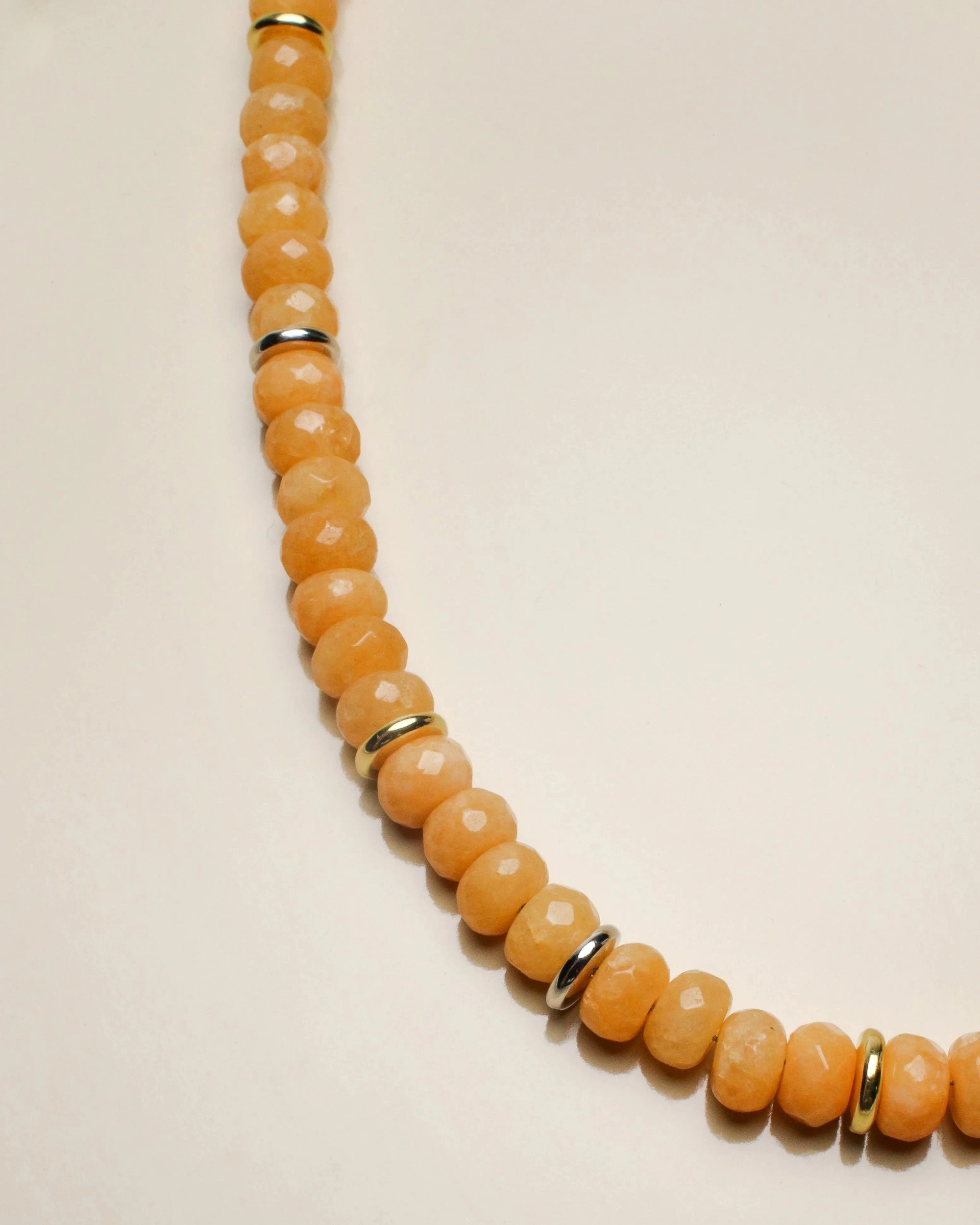 Close-up of the Zoe tangerine quartz necklace, showing detailed facets and golden accent dividers for an elegant touch.