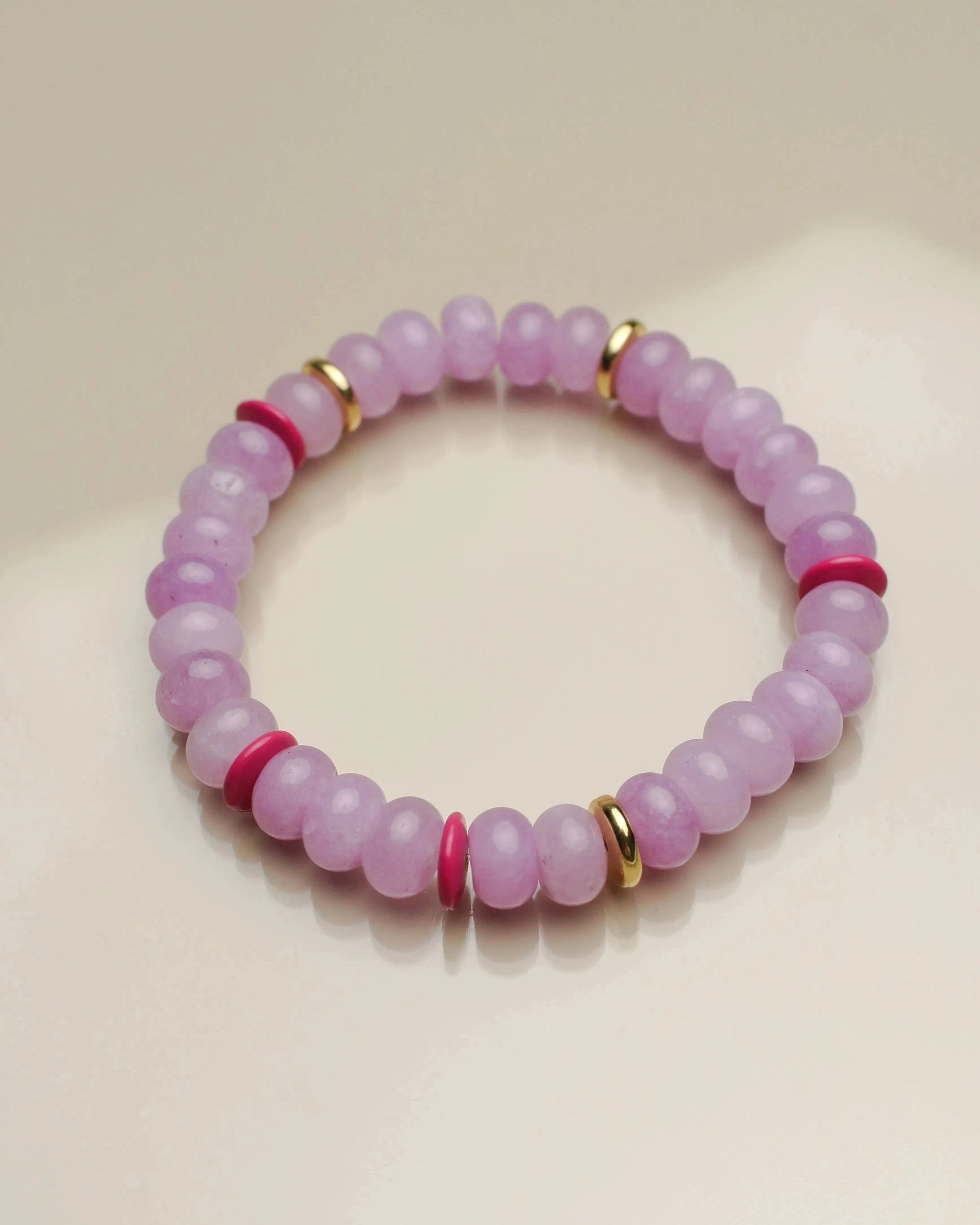 Close-up view of a single valerie lavender bracelet from the set of three, highlighting its soft purple beads with pink and gold dividers arranged in a circular layout.